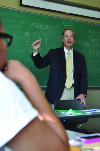 Dr. Orme teaching a politics class in his fabled favorite classroom, simply for the chalk board. 