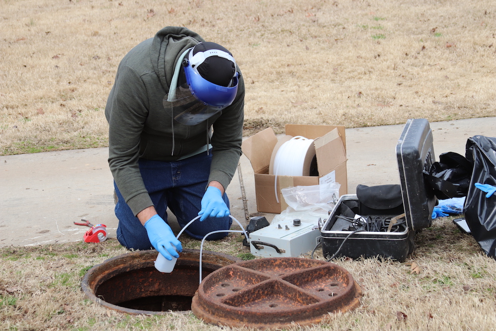 Wastewater sample being collected from manhole.