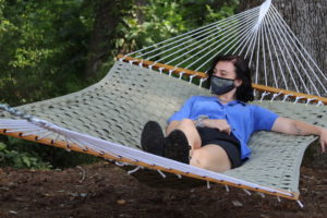 A students lounges in the hammock garden