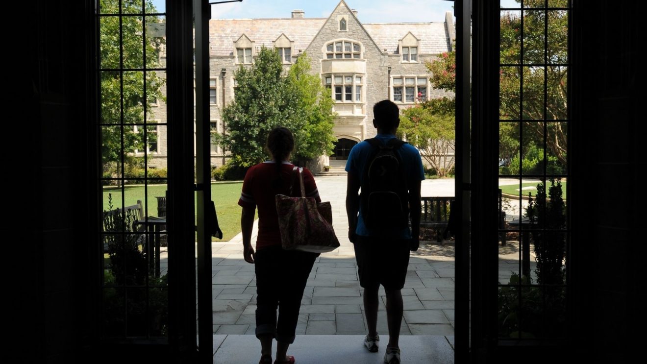 Students exit doorway opening toward Hearst Hall