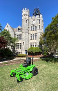 An electric lawnmower on the lawn in front of Lupton Hall