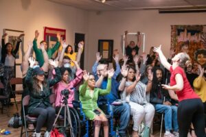 A dancer invites a crowd to lift up their hands in the Oglethorpe museum's Skylight Gallery