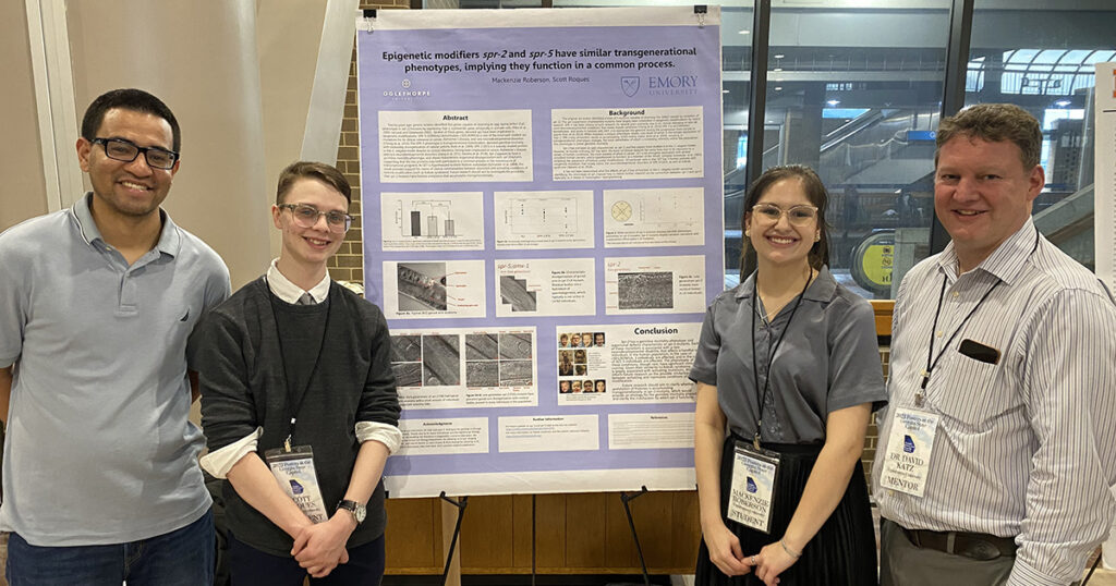 Juan Rodriguez, Scott Roques, Mackenzie Roberson and Dr. David Katz stand with a poster about epigenetics research