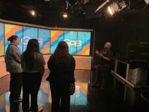 Students standing in one of Georgia Public Broadcasting's television studios with a GPB representative.