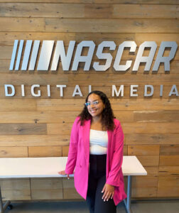 India Martin in front of a sign that reads "NASCAR Digital Media"
