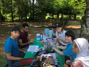 Five students at an outdoor table with various scientific implements