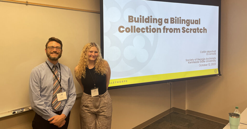 Eli Arnold and Caitlin Marshall in a classroom with a presentation screen