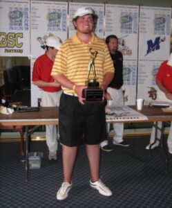 Alumnus Eric Quinn holding championship trophy