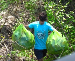 A student carries two bags of trash collected from the paths along the Atlanta BeltLine