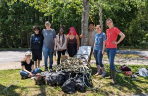 A group of students pose with a pile of trash collected from the streams on campus.