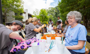 Community members smile while building and painting bird houses.